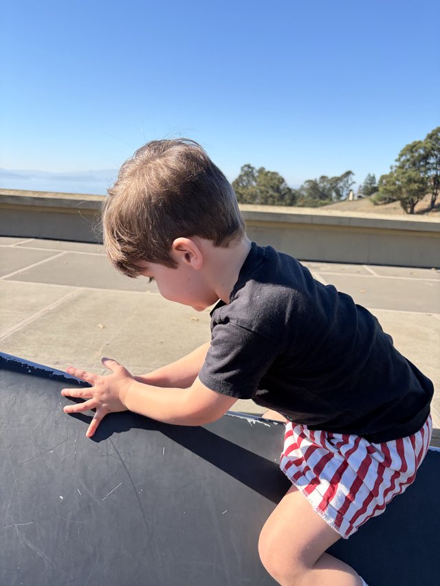 Young Boy Playing on Rooftop Parking Structure