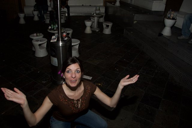 Woman Gestures Expressively in Dark Nightclub Venue