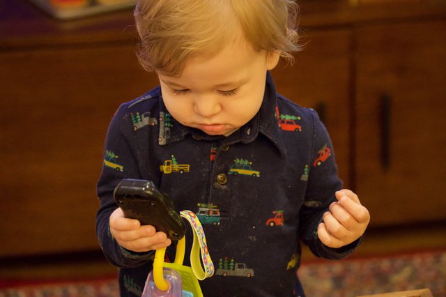 Toddler Mesmerized by Toy Vehicle at Christmas