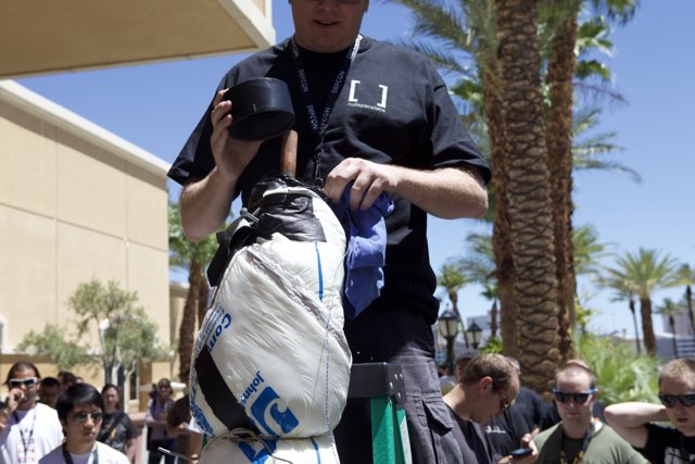 Man in Black Shirt at DefCon with Crowd and Palm Trees in Background