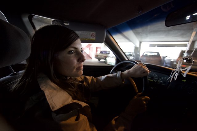 Woman Driving Through Urban Parking Structure at Night