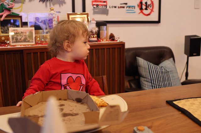 Young Child Eating Pizza at Christmas Dinner Table
