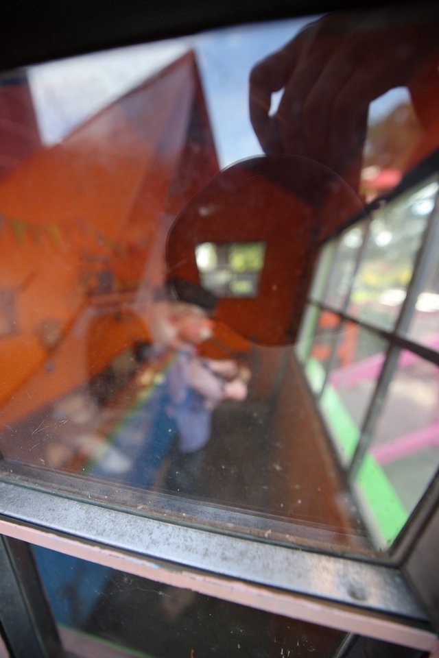 Hand Holding Toy Through Display Case Reflection