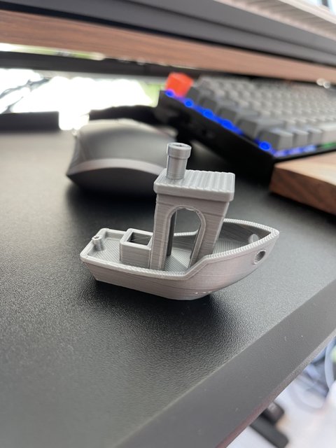 Miniature Boat for Scale Caption: A tiny boat sits peacefully on the desk next to a computer keyboard, offering a sense of whimsy and adding a unique touch to the workspace.