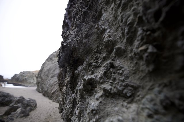 Rugged Coastal Rock Face at Low Tide Beach