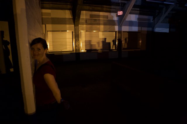Woman Smiling in Dimly Lit Industrial Space
