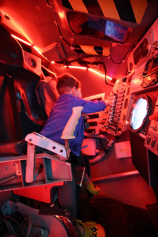 Young Visitor Operating Submarine Simulator at Science Center