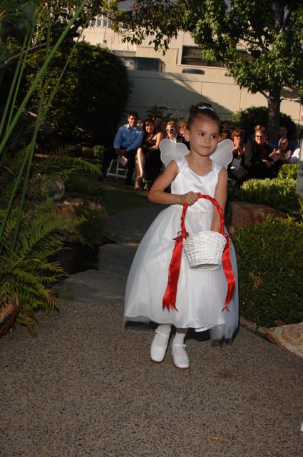 Little Girl in a Formal White Gown at a Garden Wedding