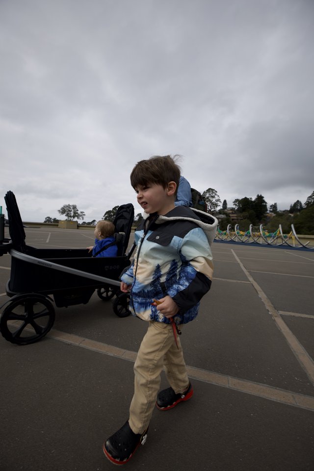 Young Boy Pulling Wagon on Cloudy Day at Parking Lot