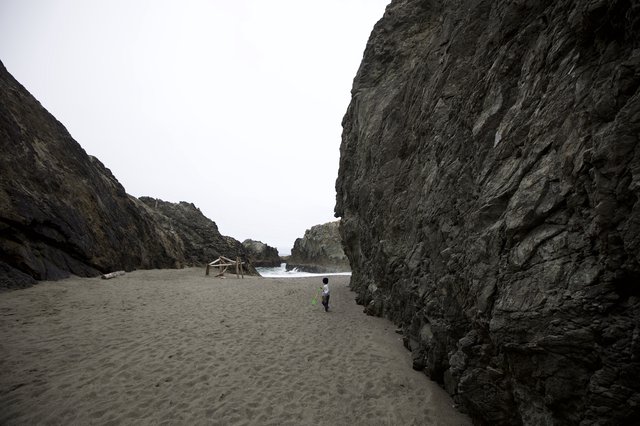 Small Child Explores Dramatic Coastal Rock Canyon