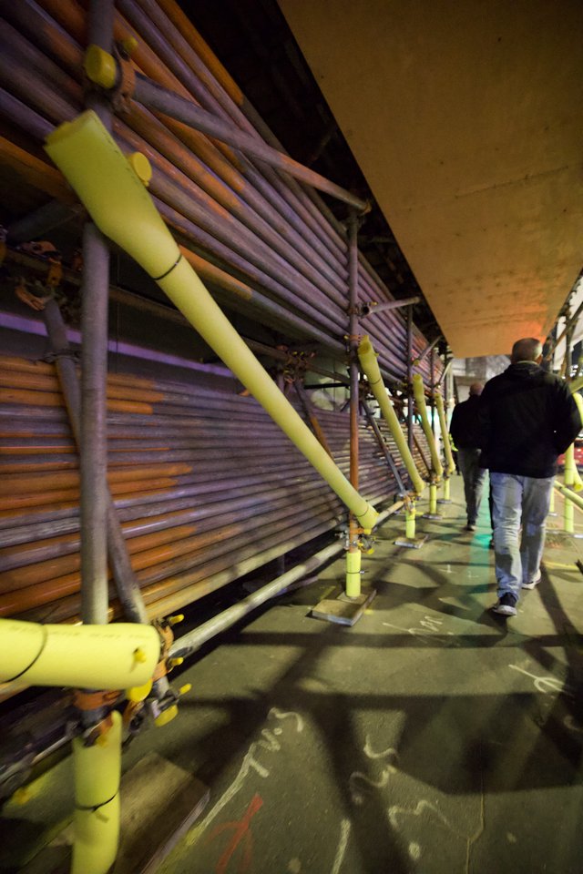 Evening Walk Under Urban Infrastructure with Yellow Safety Rails