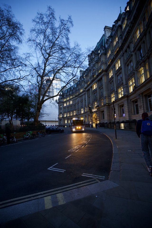 London Bus Passing Grand Building at Dusk