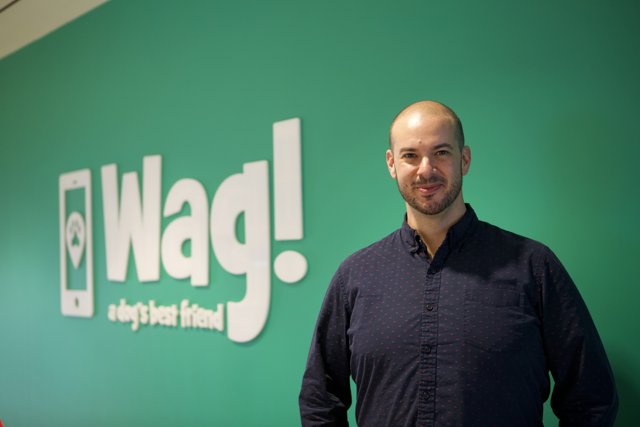 Man Poses in Front of WAG Logo