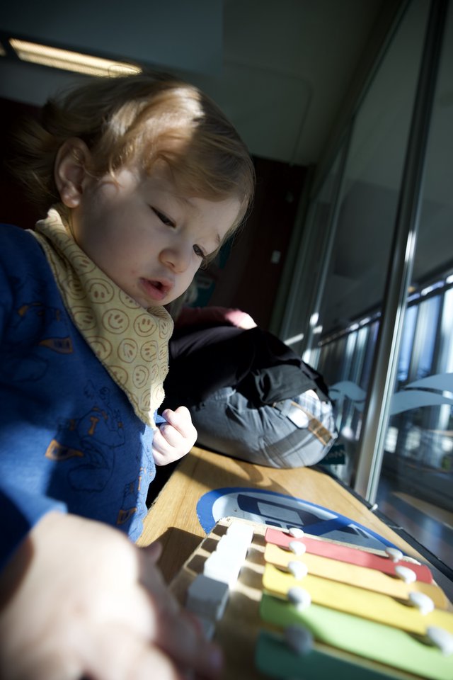 Young Child Playing with Colorful Xylophone at Home