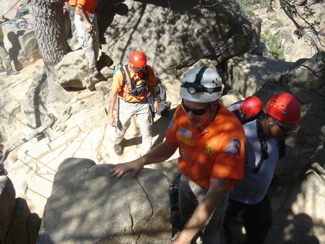 Climbing the Rock Wall in Orange Shirts