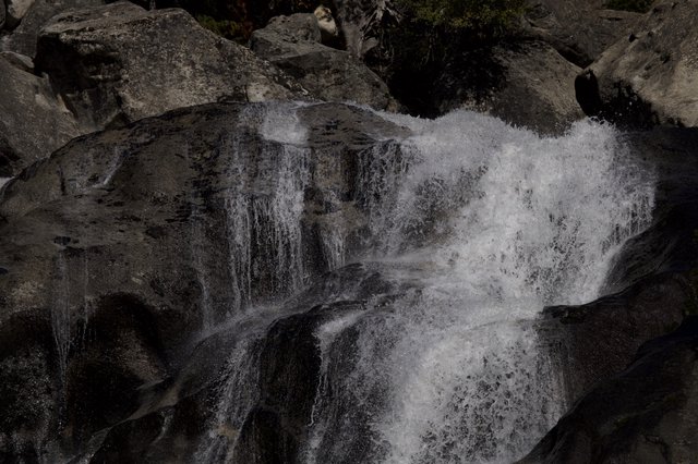 Cascading Waters Through Dark Rocky Terrain