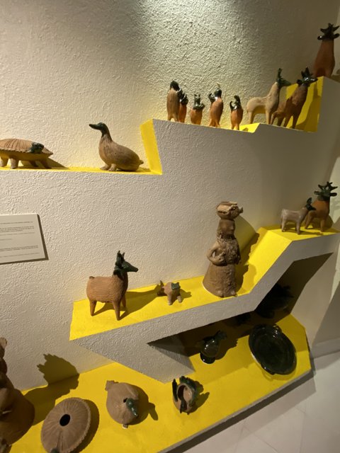 Clay Figurines and Animals on Yellow Shelf