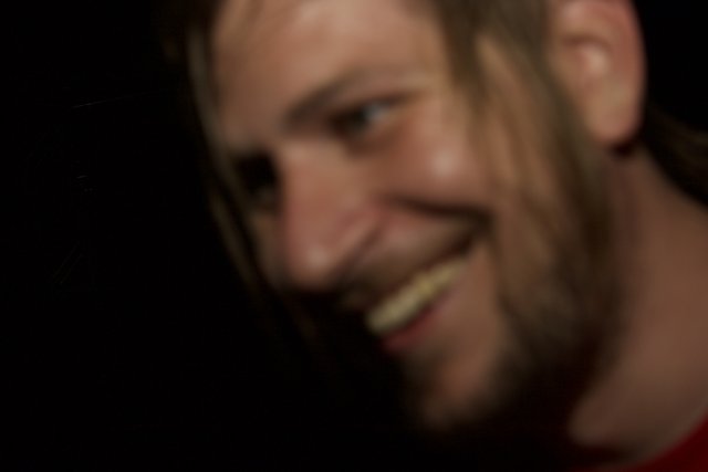 Long-haired Man Smiling in the Dark