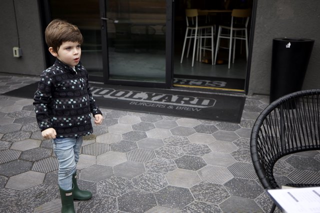 Young Boy Exploring Urban Restaurant Entrance