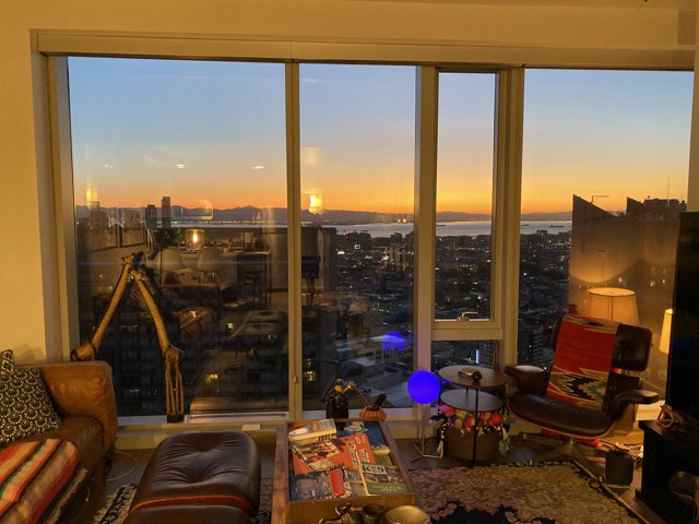 A Luxurious Living Room with a Breathtaking City View at Sunset
