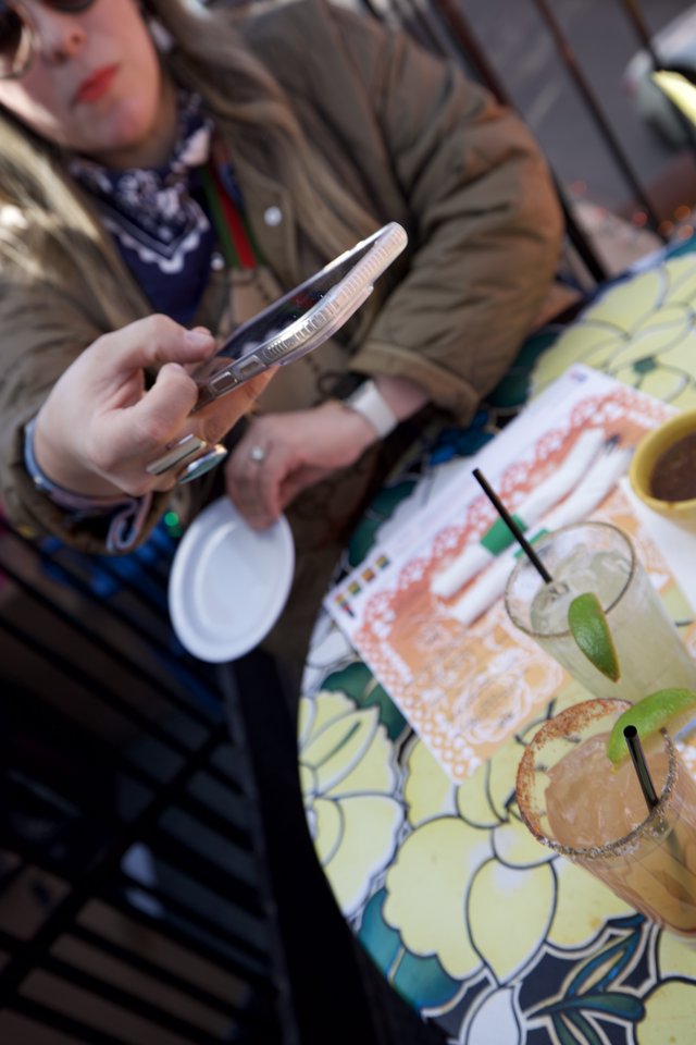 Scrolling Through Margaritas at Outdoor Cafe