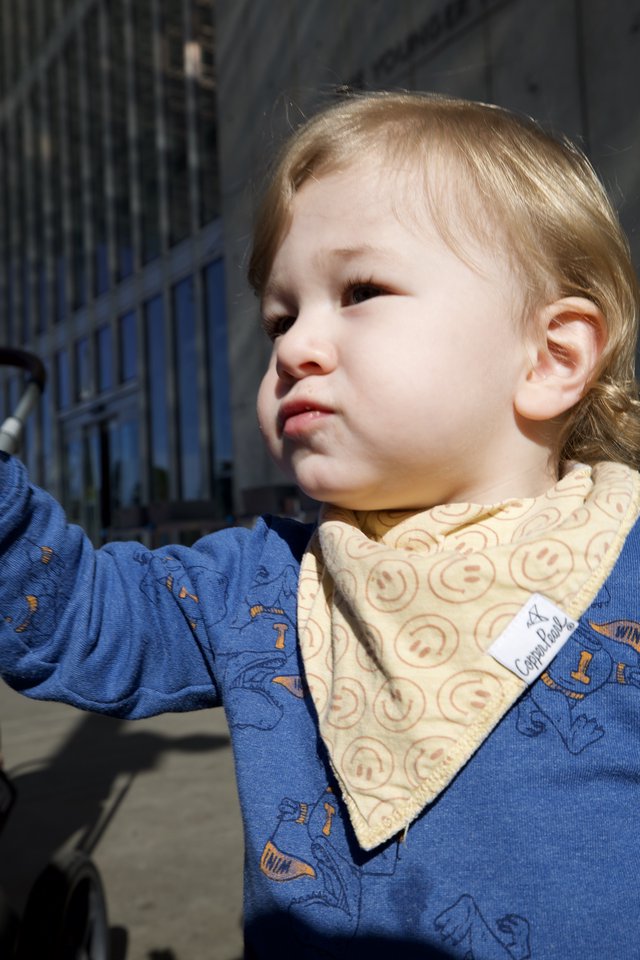 Young Child in Blue Patterned Outfit with Bib