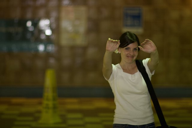 Playful Woman Making Bunny Ears in Warehouse