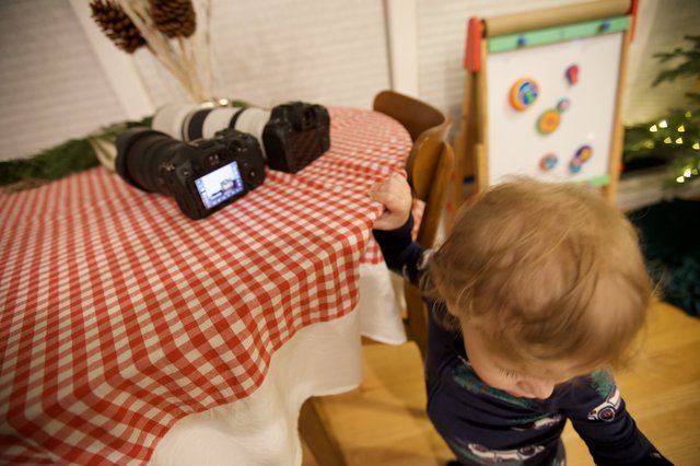 Curious Toddler Examining Professional Camera Equipment