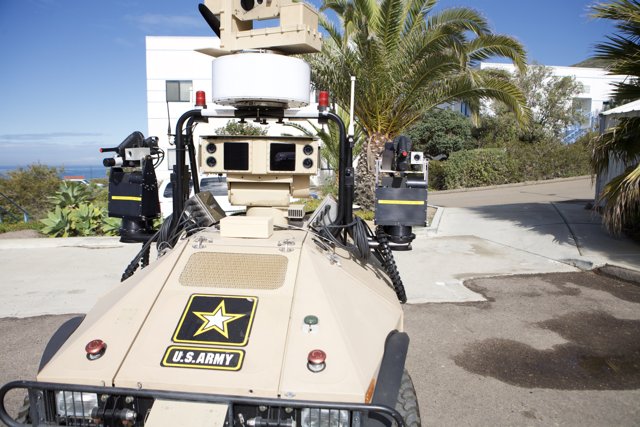 Military Vehicle with Camera in Palm Tree Surroundings