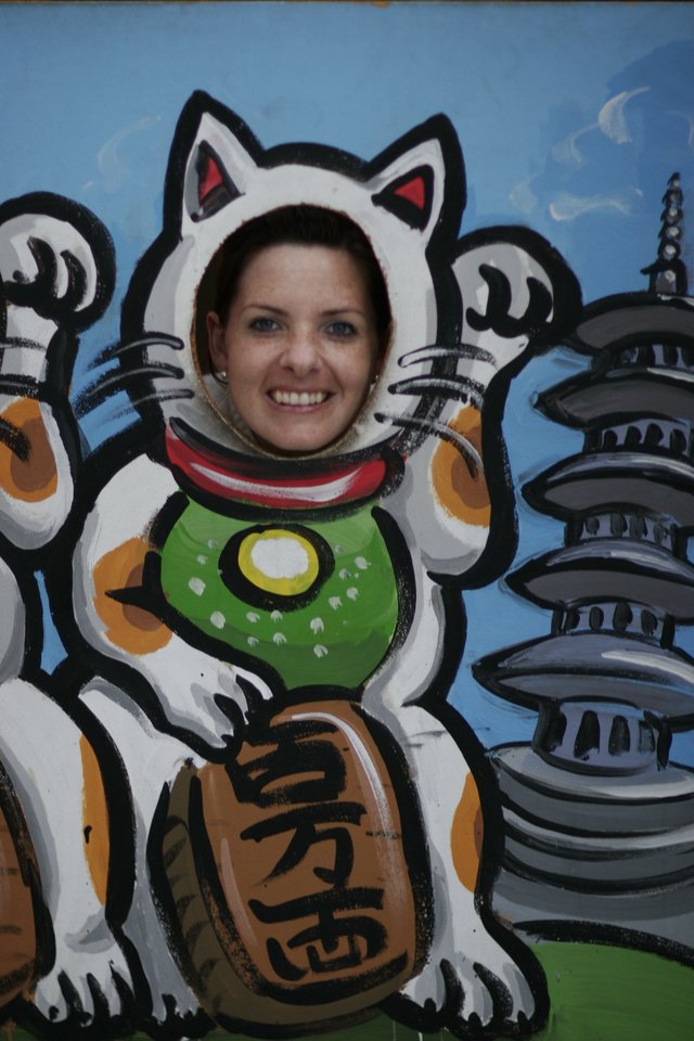 Woman Posing as Maneki-neko Lucky Cat Cutout