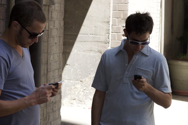Two Men Checking Their Phones
