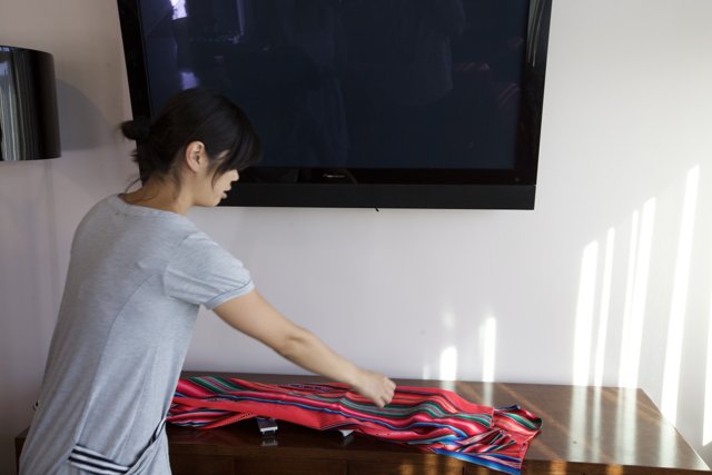 Woman Folding Clothes in a Modern Living Room