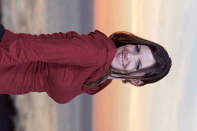 Smiling Woman at Coastal Sunset in Crimson Top