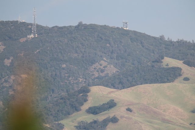 Rolling Hills and Communication Towers in Hazy Landscape