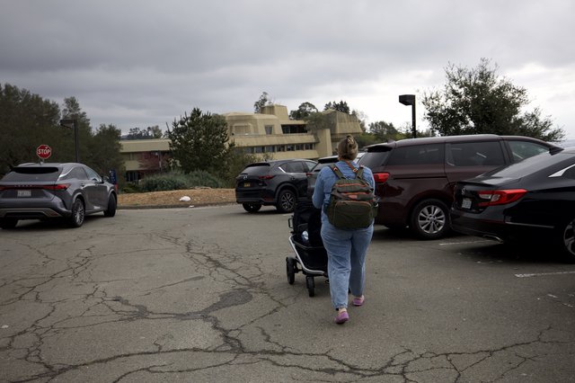 Mother and Child Navigate Parking Lot on Overcast Day