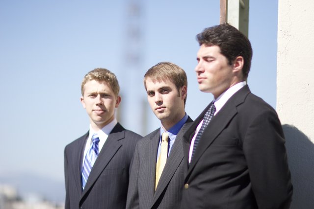 Three Men in Suits Under a Blue Sky
