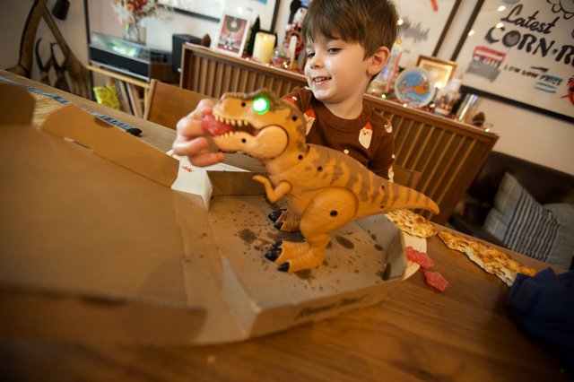 Child Playing with Interactive T-Rex Toy on Christmas