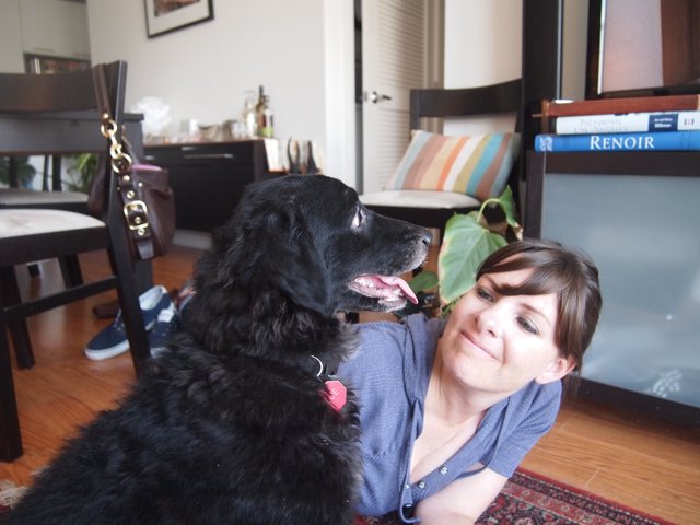Woman and Her Black Dog Share a Tender Moment