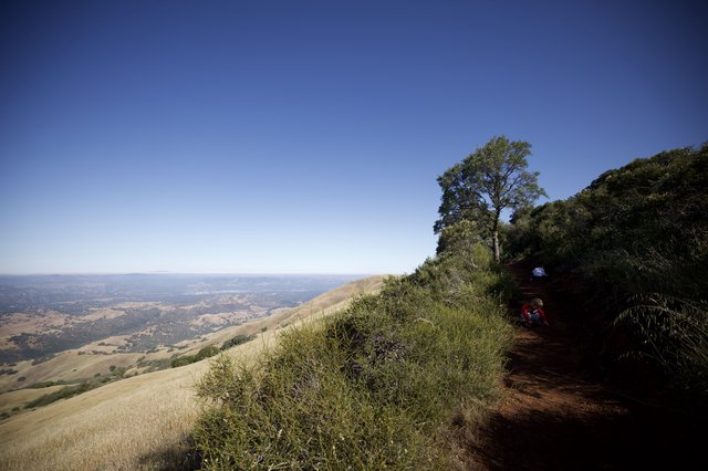 Hikers Resting on Mt. Diablo Trail Above the Valley