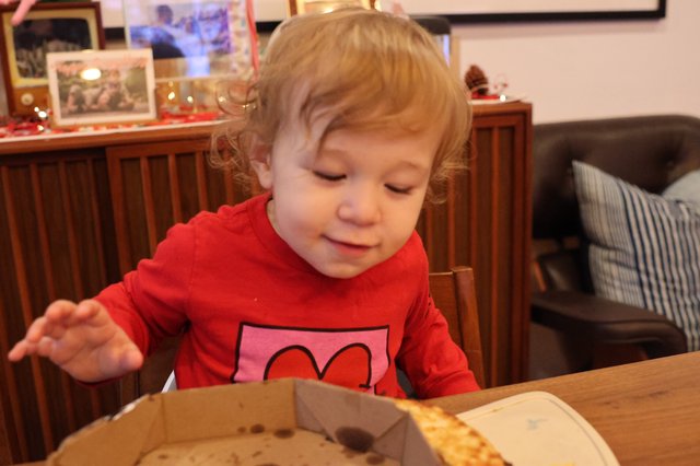 Toddler Enjoying Pizza at Christmas Dinner