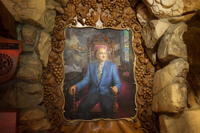 Ornate Portrait in Gilded Frame Against Stone Grotto