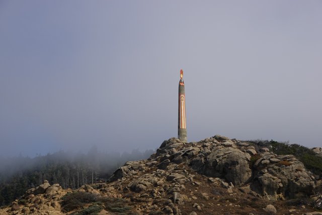 Towering Beacon amidst the Foggy Mountains