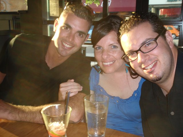 Three Friends Smiling Together at Restaurant Table