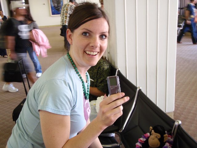 Smiling Woman Shows Off Phone at Hawaiian Airport