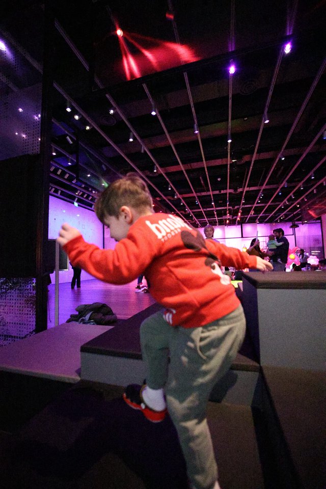 Child Dancing at Purple-Lit Baby Rave Museum Event