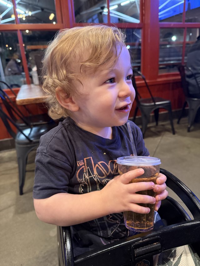 Young Child Enjoying a Drink at Restaurant