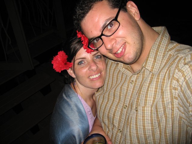 Couple Smiling Together with Red Flowers at Night