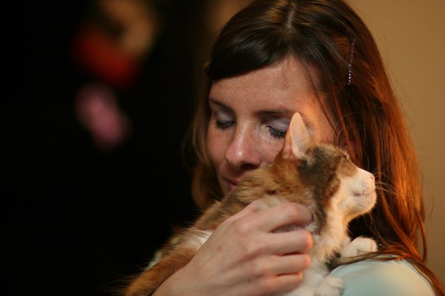 Tender Moment: Woman Nuzzles Ginger Kitten Lovingly