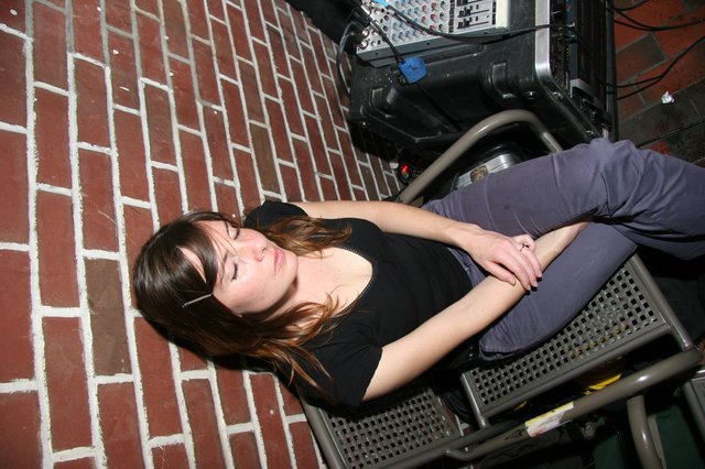 Contemplative Woman Resting Backstage at Music Venue