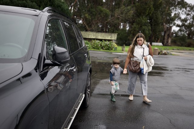 Mother and Child Walking to Car on Rainy Day